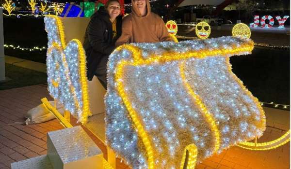 A couple sitting in an illuminated sleigh during the 5 Season Lights Festival at the McGrath Amphitheater in Cedar Rapids