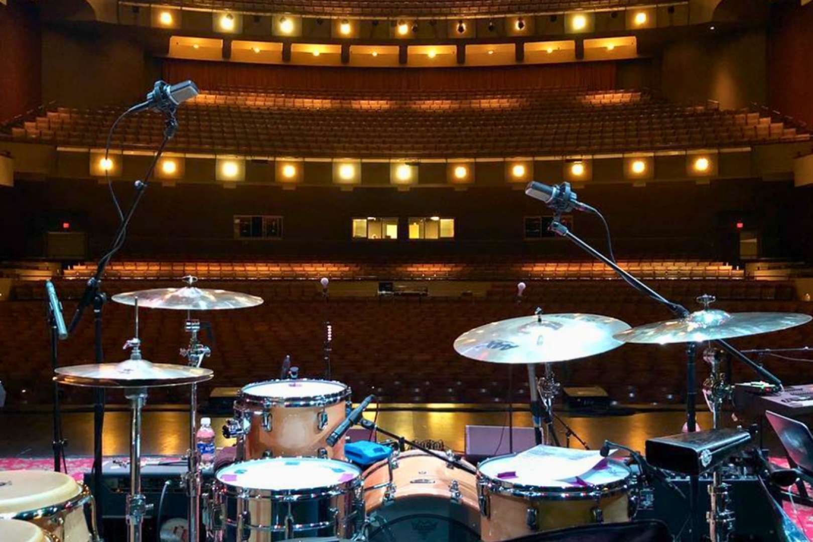 Photo of a photo of a drum kit on stage at the Aiken Theater taken from the rear of the stage facing the seating and balconies