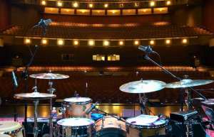 Thumbnail photo of a photo of a drum kit on stage at the Aiken Theater taken from the rear of the stage facing the seating and balconies