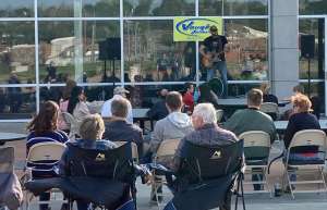 Thumbnail photo of people sitting watching a concert at the Bridge View Center Outdoor Plaza