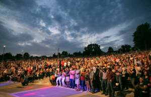 Thumbnail photo of Large audience on their feet at the Capital Region MU Healthcare Amphitheater