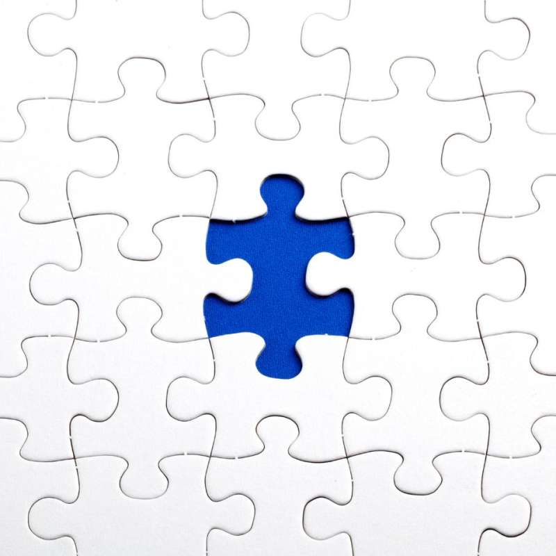 White puzzle with one blue piece sticking out in the middle