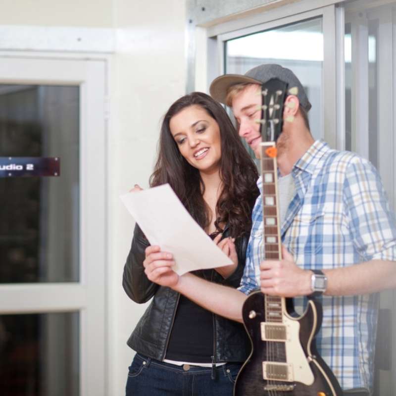 2 musicians looking at a contract