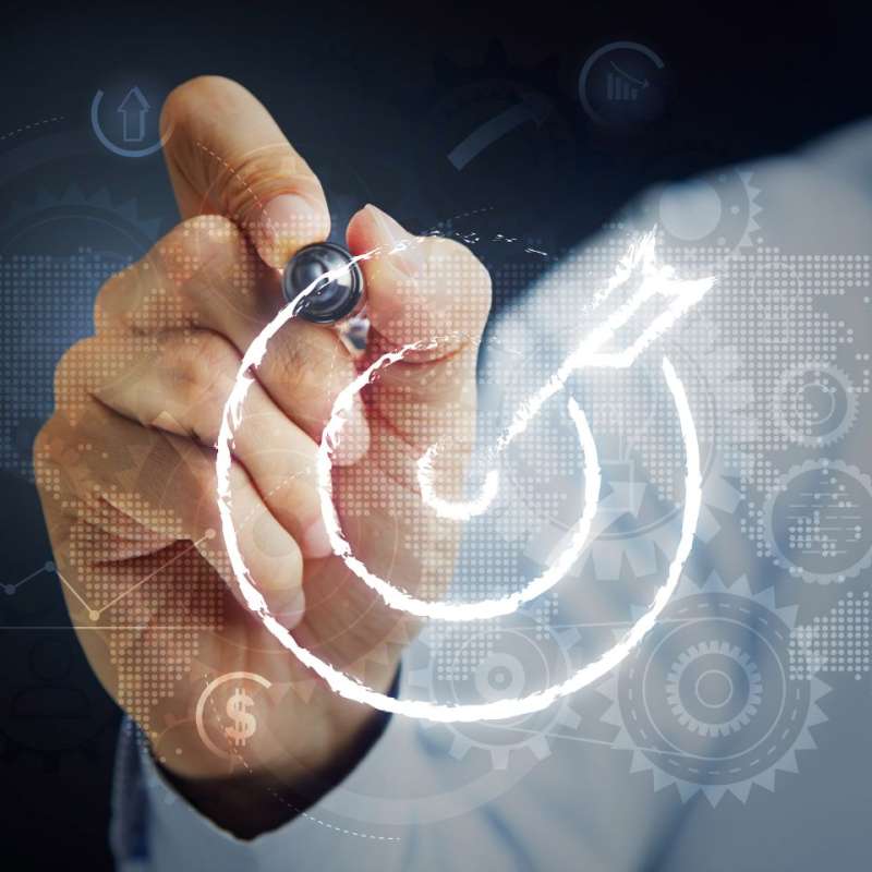 Person drawing on clear surface with stylus, drawing is the shape of a target with an arrow hitting bullseye