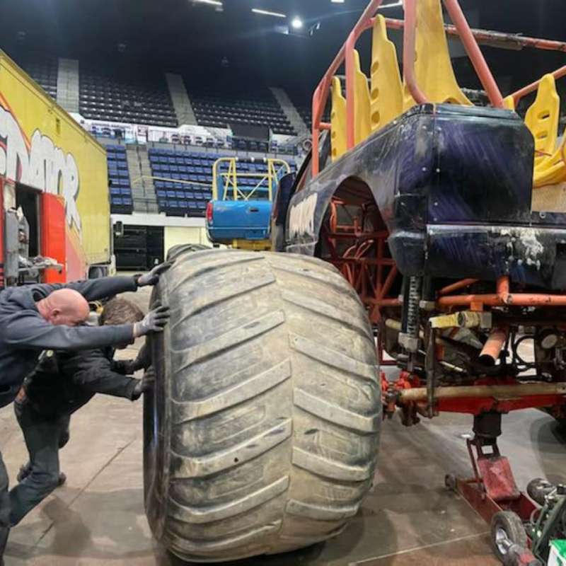 Crew moving a monster truck into place in an arena