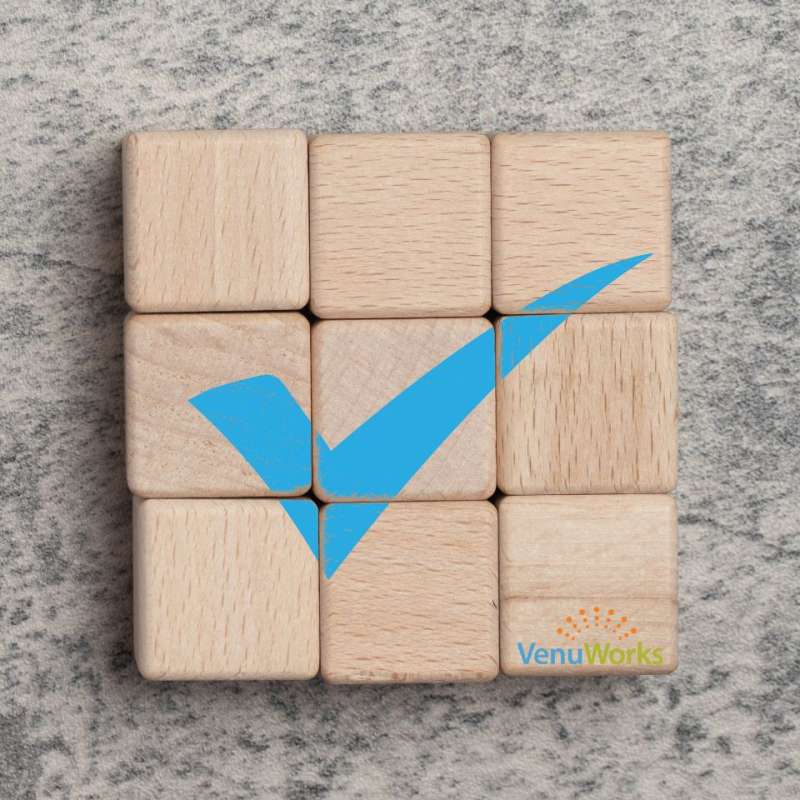 a wooden 9 square grid game with a check mark in the center