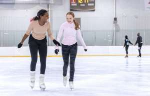Thumbnail photo of 2 girls laughing on the ice