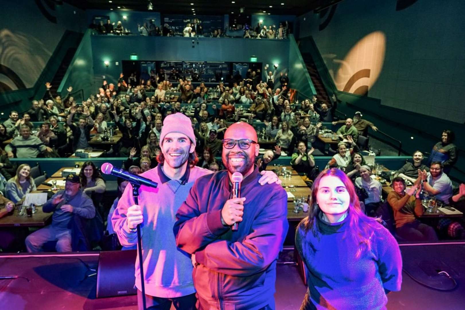 Photo of Members of Dante's Comedy Review on Stage with the audience in the background waving and cheering