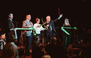 Thumbnail photo of Steve Peters, Connor Delaney (Ingersoll co-owners) on stage with Des Moines Mayor Connie Boysen, cutting the ribbon to open the Ingersoll Theater