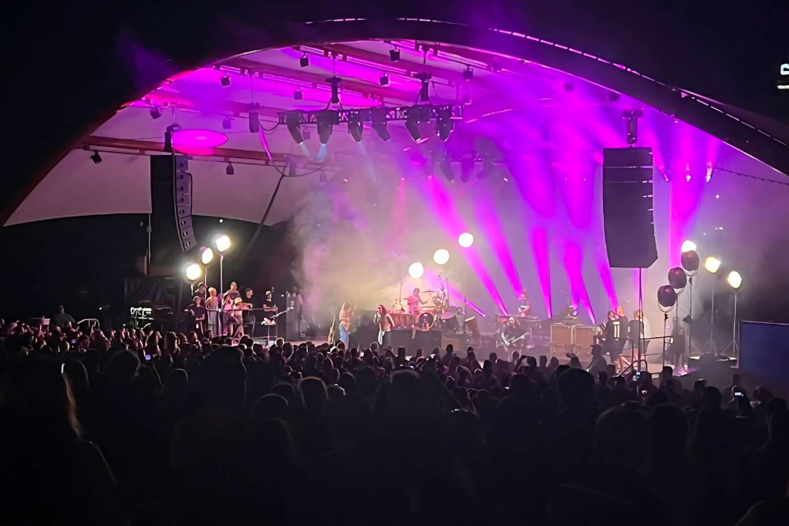 Photo of Band on stage at the McGrath Amphitheatre, light show and audience looking on