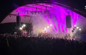 Thumbnail photo of Band on stage at the McGrath Amphitheatre, light show and audience looking on