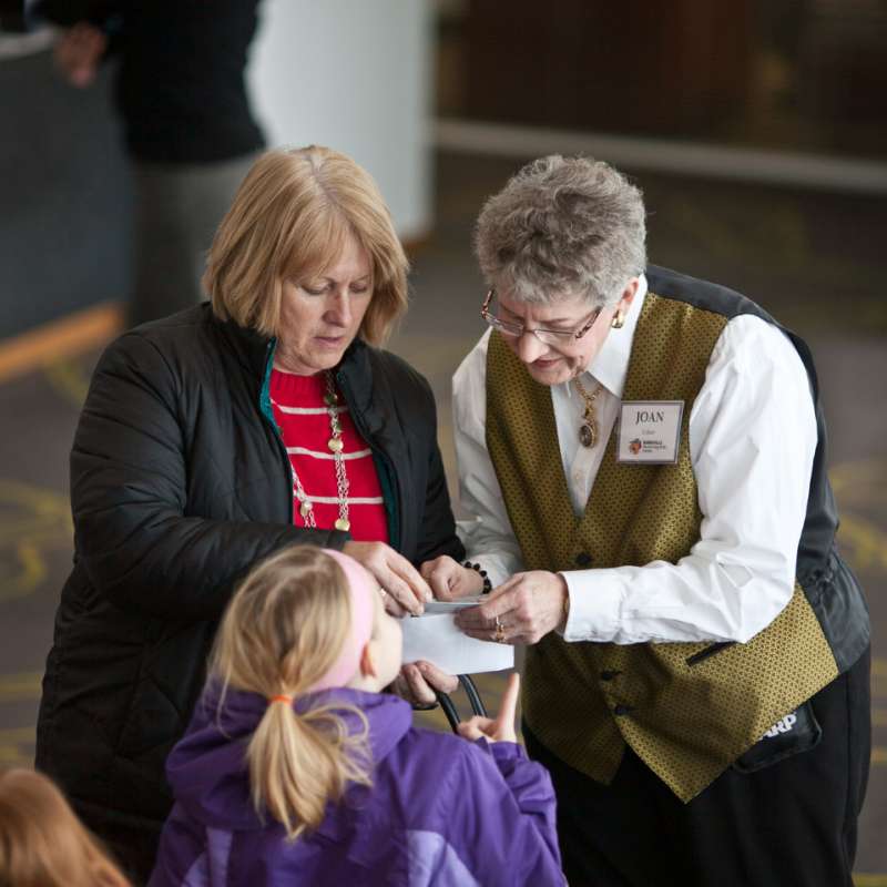 Two women talking with child at VenuWorks event