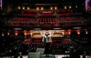 Thumbnail photo of Person on stage looks into the theatre house lights on