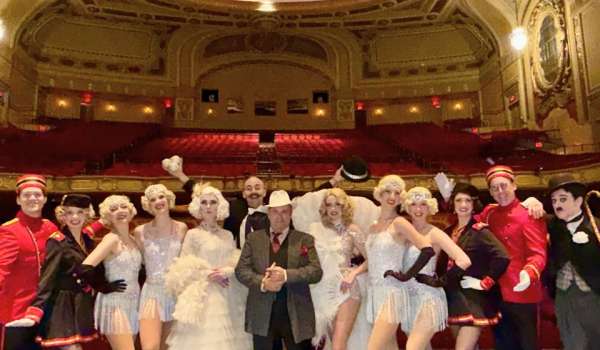 a group of actors in 1920s dress on stage at the rialto square theatre before the 100th anniversary gala in May 2026