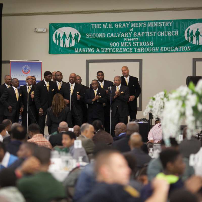 a group of men from a baptist church talking to a crowd at a meeting