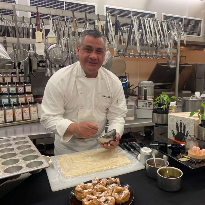 Chef in white coat preparing dough for baking