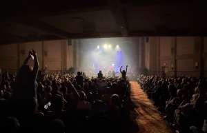 Thumbnail photo of Live Rock Band playing at the Sunrise Theatre with audience in silhouette and on their feet