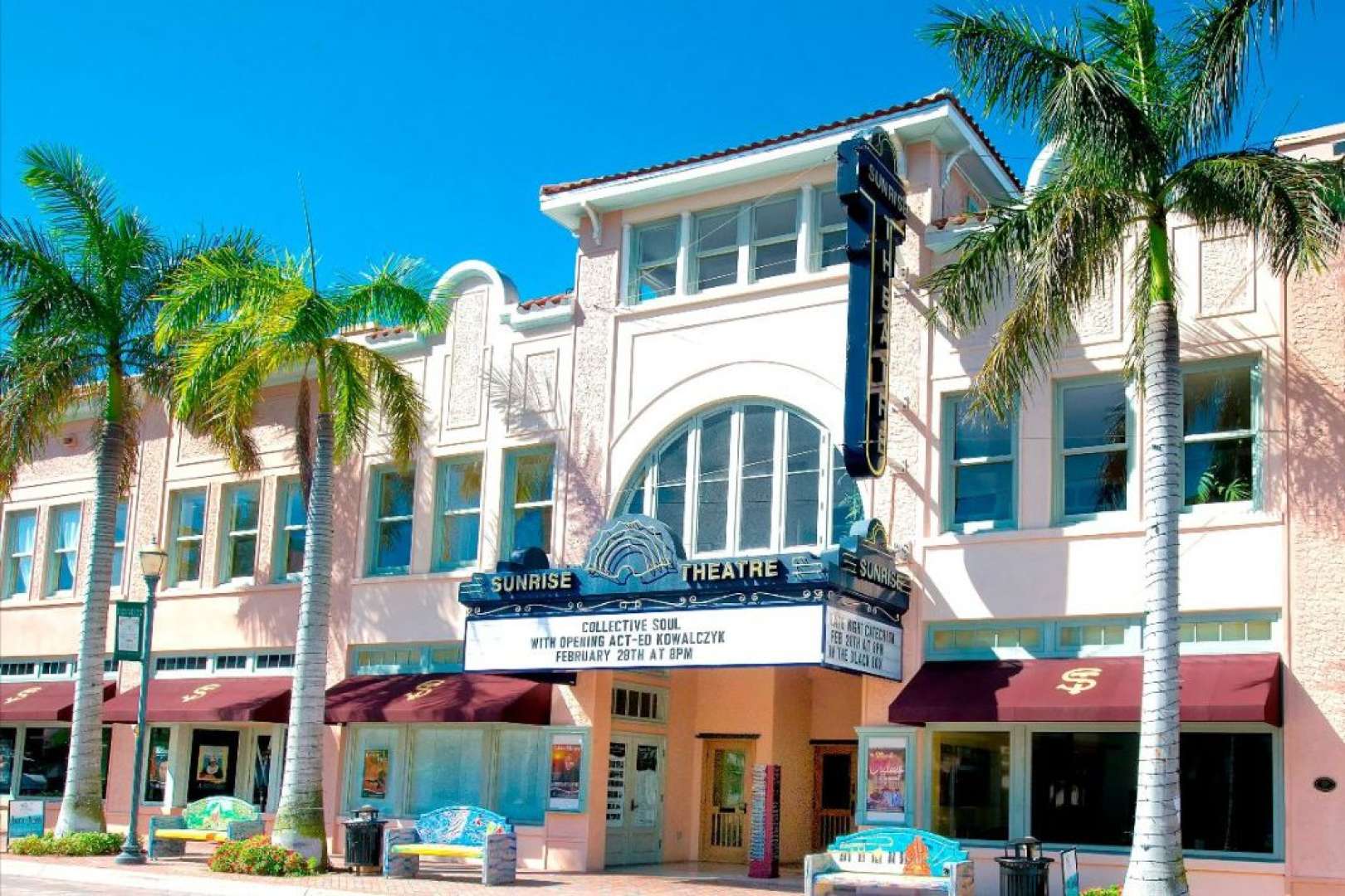 Photo of External shot of the Sunrise Theatre in Fort Pierce taken during daytime. Theatre entrance is flanked by palm trees.