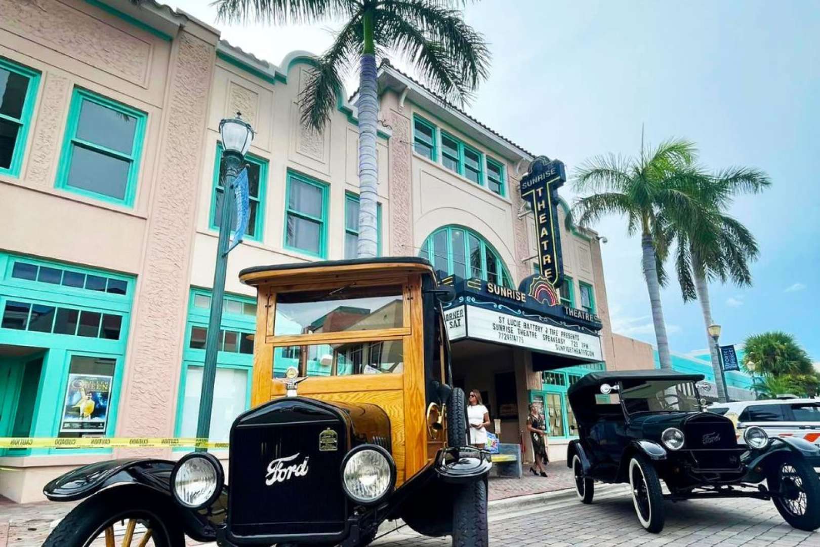 Photo of External shot of the Sunrise Theatre in Fort Pierce taken during daytime with 2 vintage cars parked out front of the Theatre entrance.
