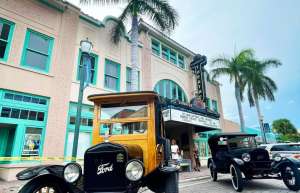 Thumbnail photo of External shot of the Sunrise Theatre in Fort Pierce taken during daytime with 2 vintage cars parked out front of the Theatre entrance.