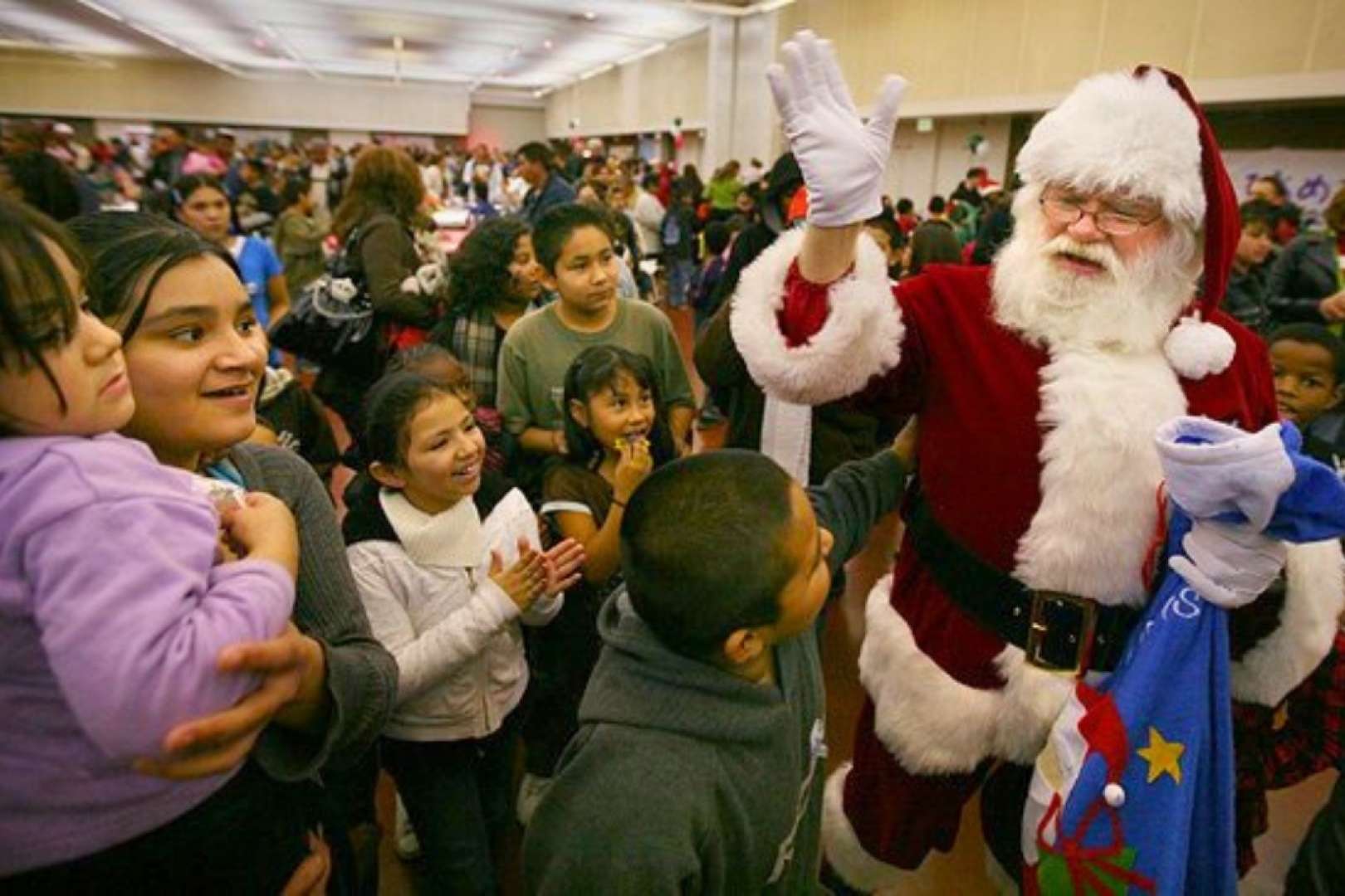 Photo of Santa Claus greets a crowd of children at the Valdez Hall