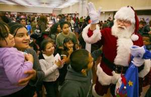 Thumbnail photo of Santa Claus greets a crowd of children at the Valdez Hall