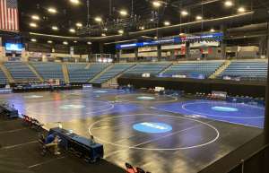 Thumbnail photo of A venue preparing for a wrestling competition, with the floor set up