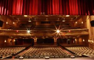 Thumbnail photo of The Sunrise Theatre taken from the Stage looking towards the House, empty and lit.